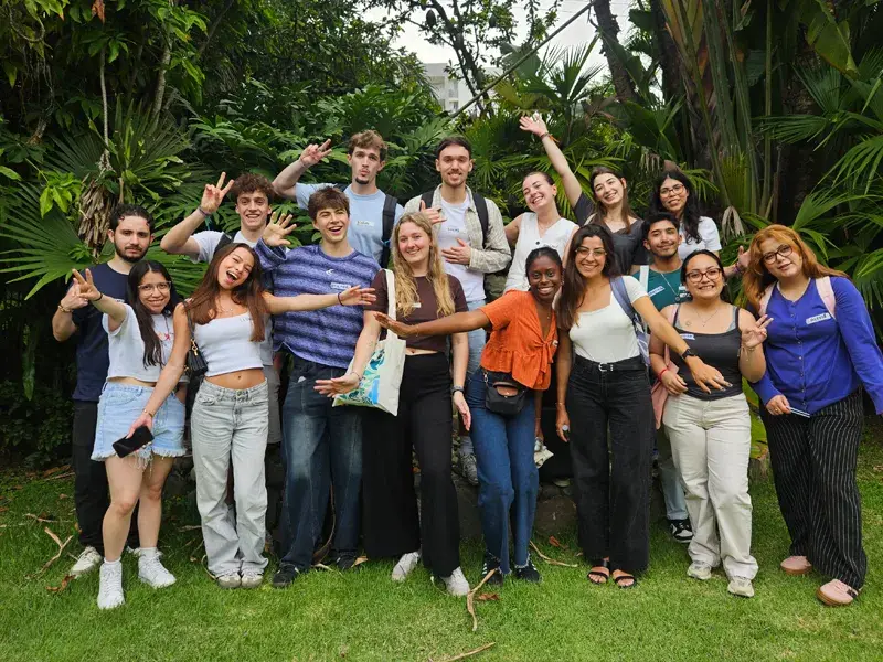 Grupo de estudiantes fotos locales e internacionales posando juntos en zona verde de la Javeriana Cali